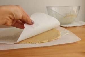 masa de galletas de lim&oacute;n veganas estirada entre papeles