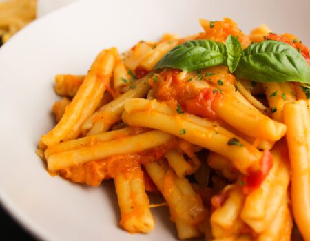 plato de pasta con salsa roja y albahaca
