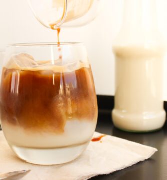 Café frío con leche en un vaso de cristal con hielos