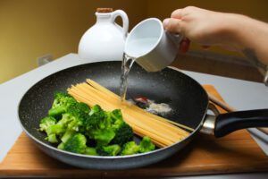 imagen de sart&eacute;n con pasta, br&oacute;coli y agua