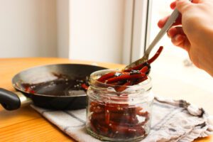 zanahorias siendo colocadas en un frasco de vidrio
